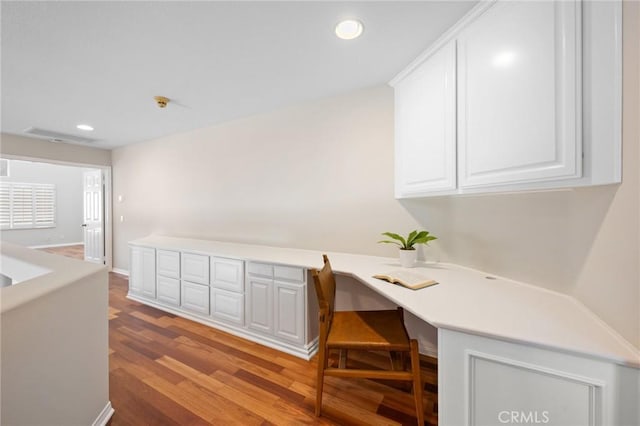 office featuring built in desk and light hardwood / wood-style floors