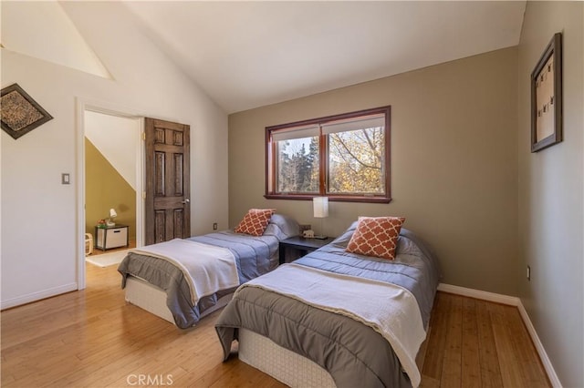 bedroom featuring light hardwood / wood-style floors and lofted ceiling