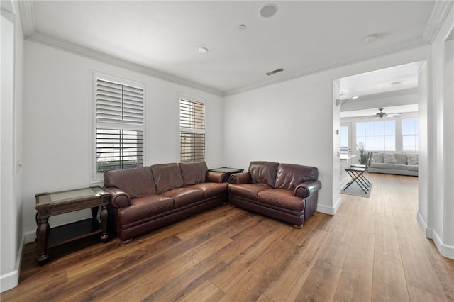 living room featuring ceiling fan, wood-type flooring, and ornamental molding