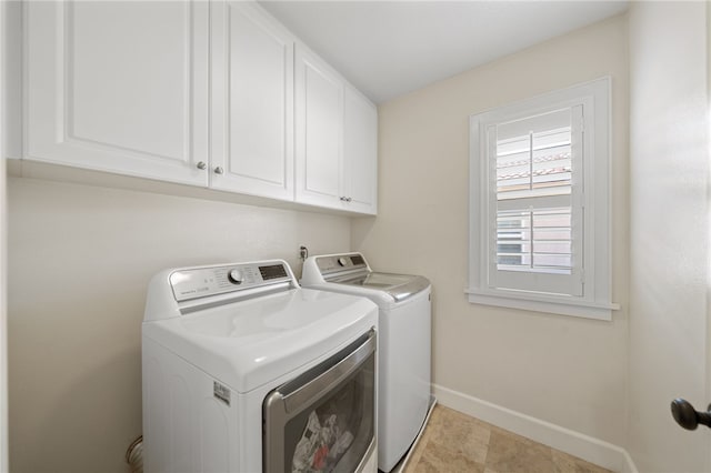 laundry room with separate washer and dryer and cabinets