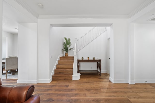 stairway featuring wood-type flooring and crown molding