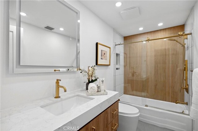 full bathroom featuring toilet, vanity, and combined bath / shower with glass door