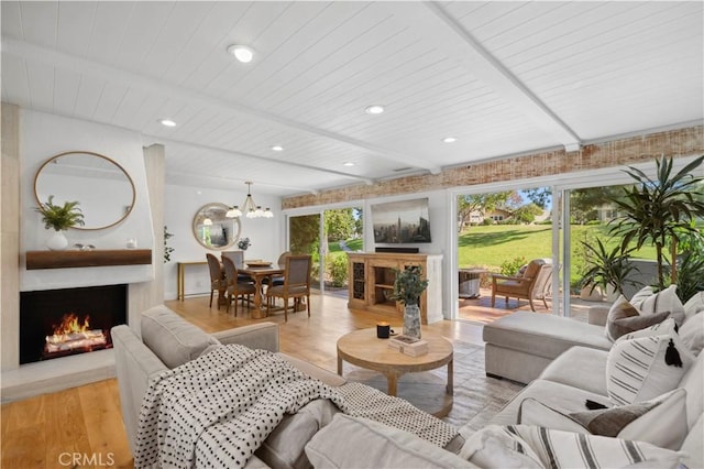 living area featuring a large fireplace, a wealth of natural light, and beamed ceiling