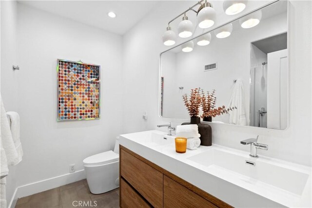 bathroom featuring tile patterned floors, vanity, and toilet