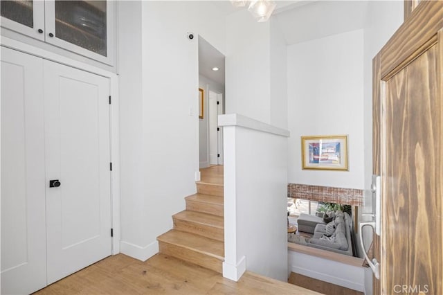 staircase featuring a brick fireplace and wood finished floors