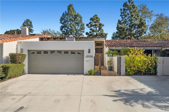 mediterranean / spanish house featuring a garage, a tiled roof, concrete driveway, and stucco siding