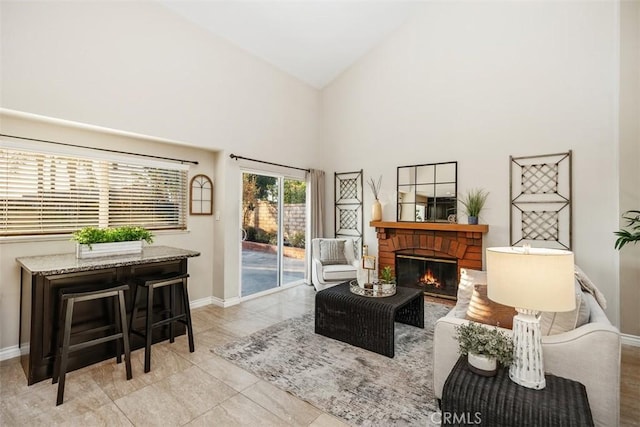 sitting room featuring a fireplace and high vaulted ceiling