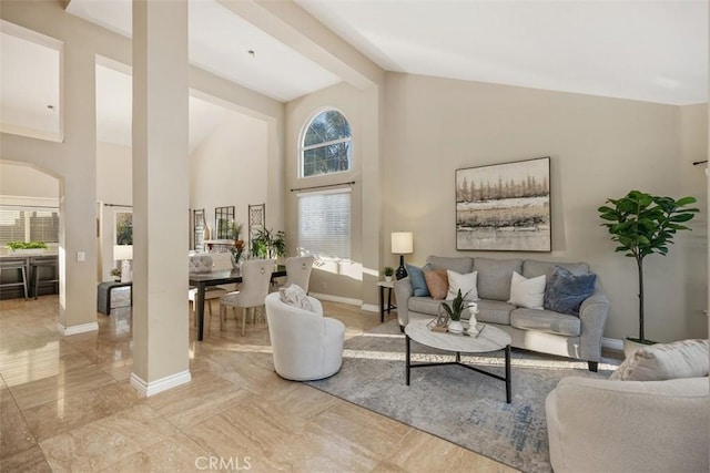 living room with beam ceiling, high vaulted ceiling, and plenty of natural light