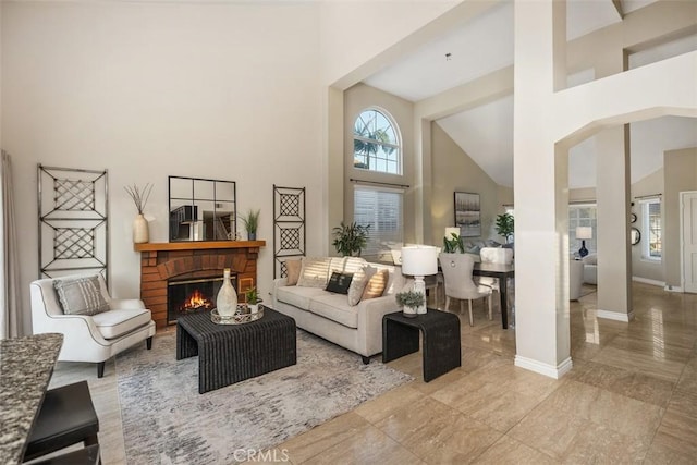 living room with a high ceiling and a brick fireplace