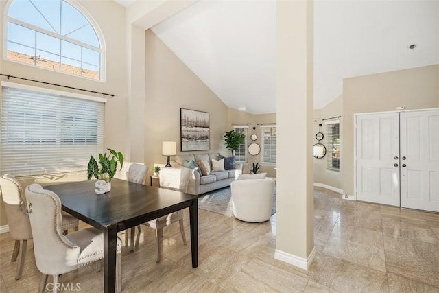 dining space with high vaulted ceiling