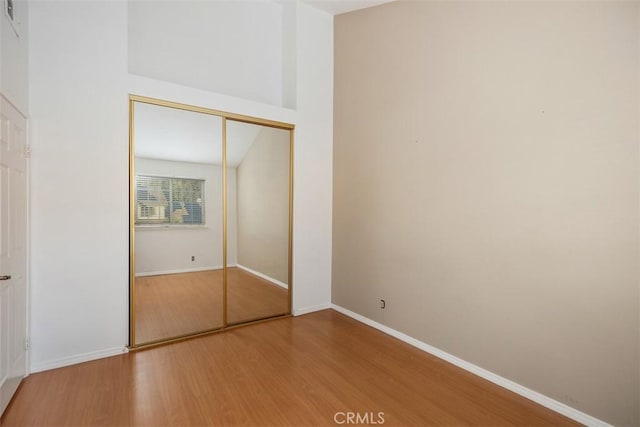 unfurnished bedroom with wood-type flooring and a closet