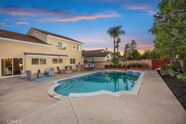 pool at dusk with a patio area