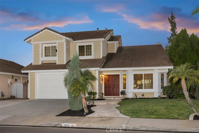 view of front facade with a yard and a garage