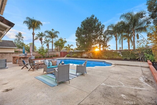 view of pool with a fire pit, an outdoor kitchen, and a patio area