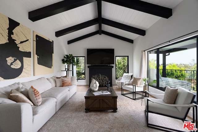 living room featuring lofted ceiling with beams and a wealth of natural light