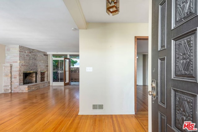 entrance foyer featuring hardwood / wood-style flooring, expansive windows, and a fireplace