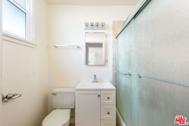 bathroom featuring an enclosed shower, vanity, and toilet