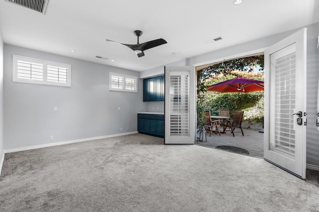 unfurnished living room featuring carpet, ceiling fan, and french doors