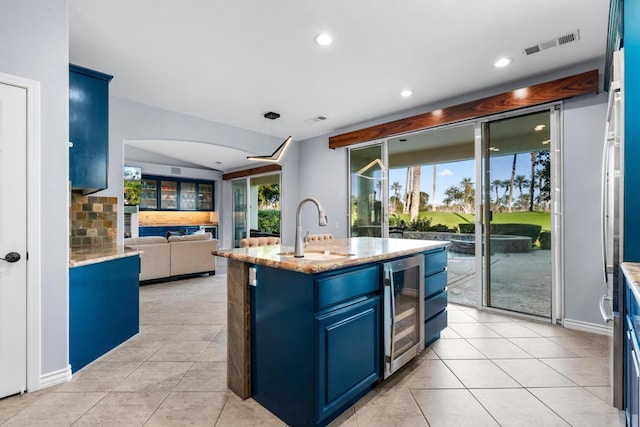 kitchen featuring tasteful backsplash, sink, an island with sink, and a healthy amount of sunlight