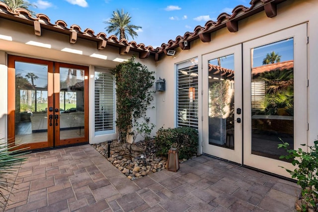 view of exterior entry featuring a patio area and french doors