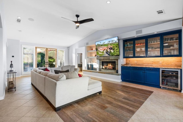 tiled living room featuring indoor bar, wine cooler, ceiling fan, and lofted ceiling