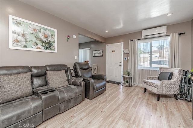 living room with light wood-type flooring and an AC wall unit