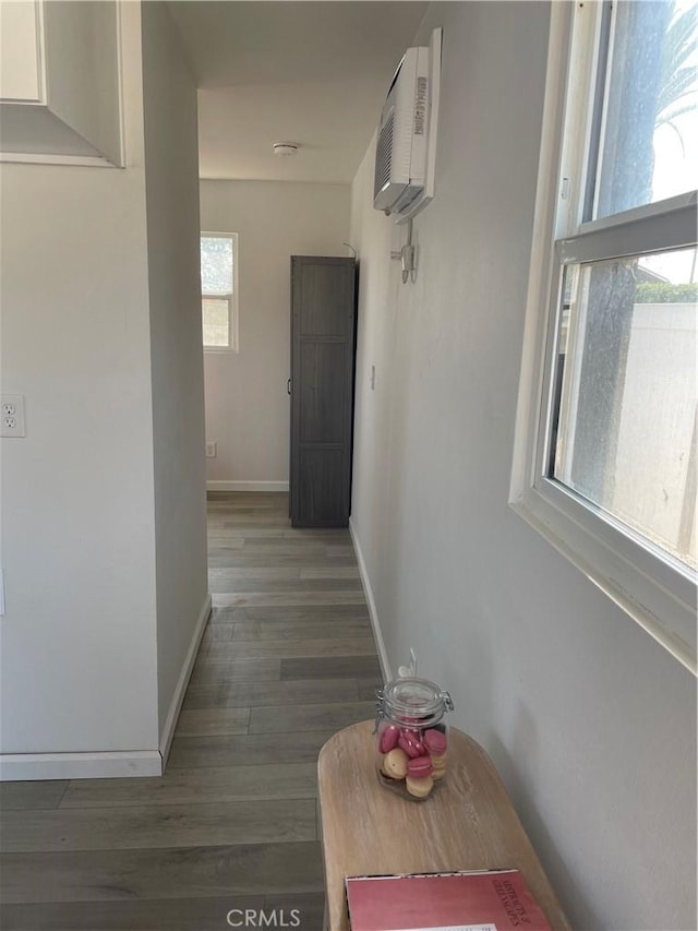 hall featuring dark hardwood / wood-style floors and an AC wall unit