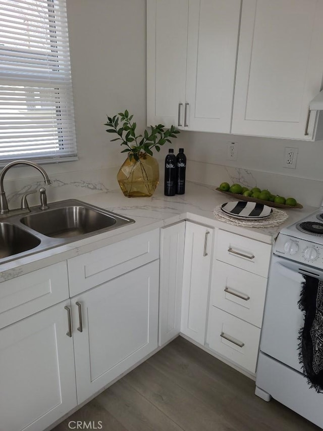 kitchen with light stone countertops, sink, dark wood-type flooring, white cabinets, and white stove