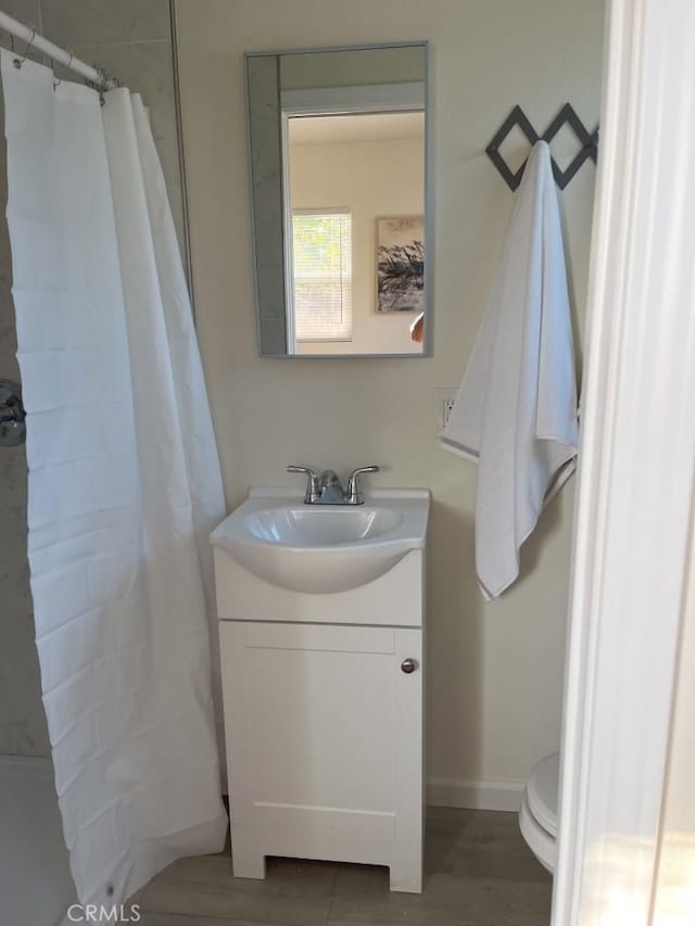 bathroom with vanity, hardwood / wood-style flooring, toilet, and walk in shower