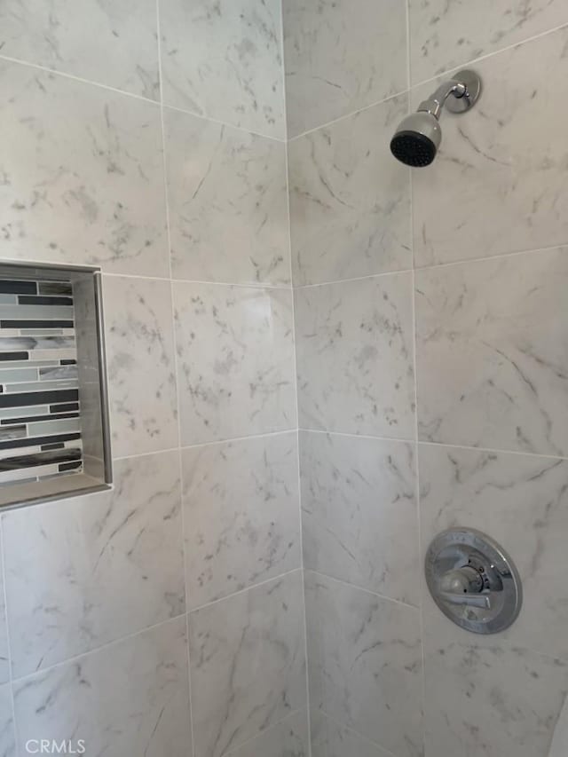 interior details featuring a tile shower