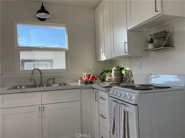 kitchen featuring white cabinets, white range, and sink