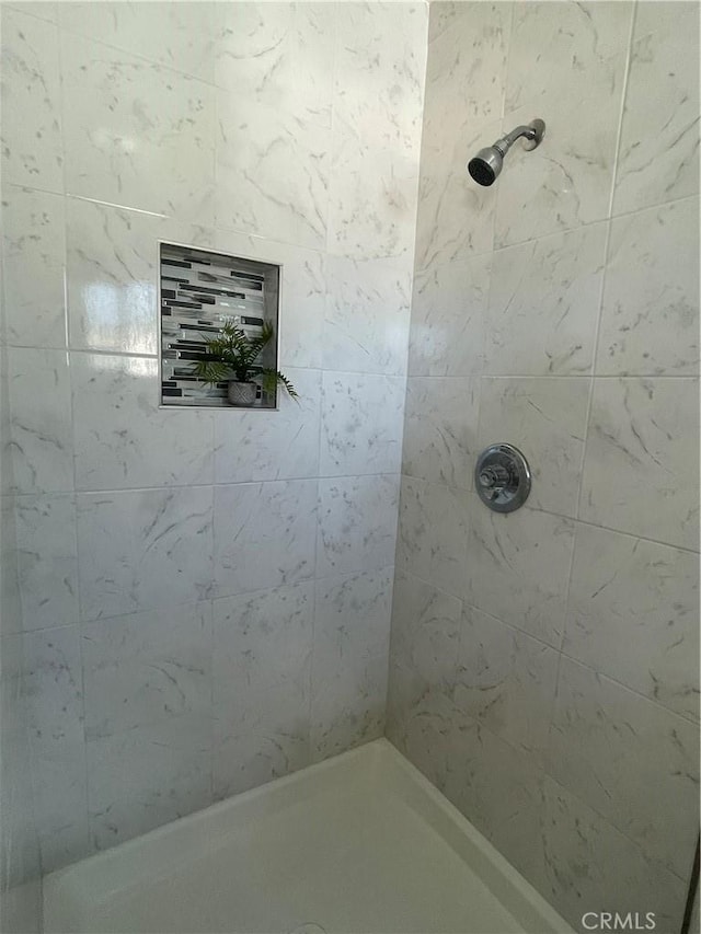 bathroom featuring a tile shower