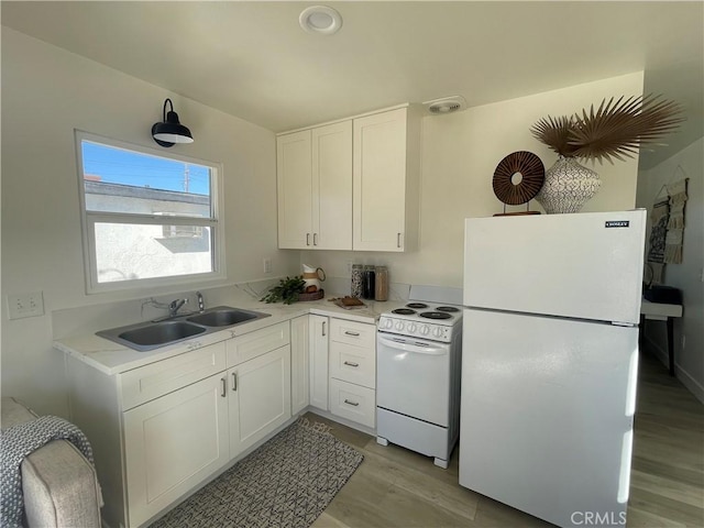 kitchen featuring white cabinetry, light wood-type flooring, white appliances, and sink