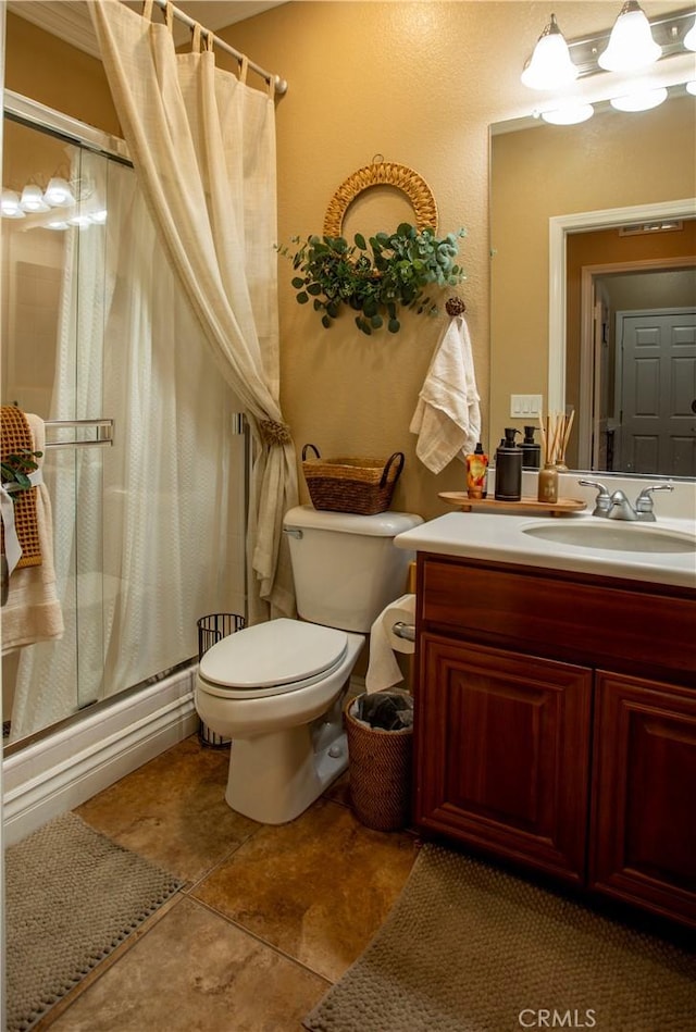 full bathroom featuring tile patterned floors, vanity, enclosed tub / shower combo, and toilet