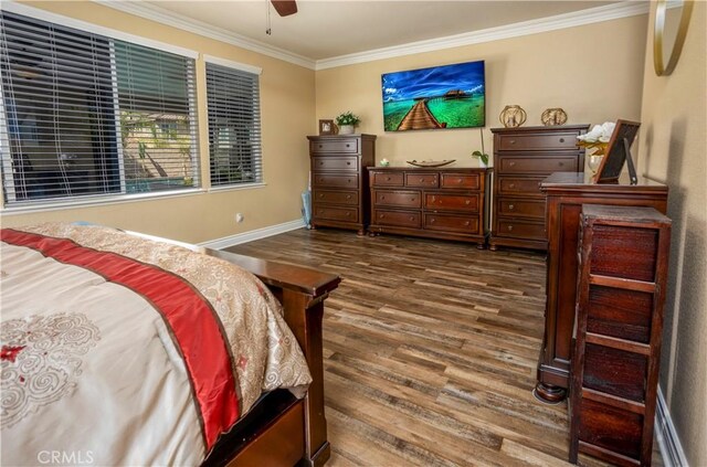 bedroom with ceiling fan, dark hardwood / wood-style flooring, and ornamental molding