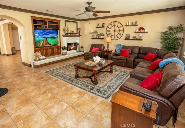 living room with tile patterned floors, ceiling fan, and ornamental molding