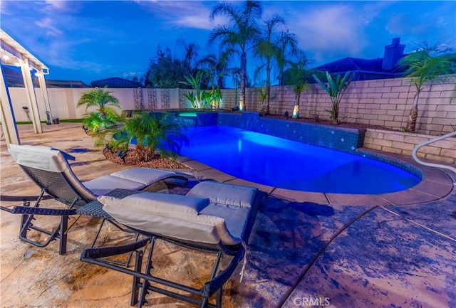 pool at dusk featuring a patio area