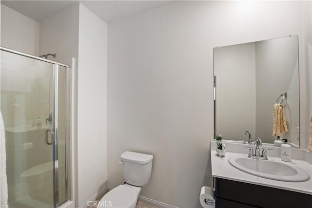 bathroom featuring vanity, toilet, and an enclosed shower