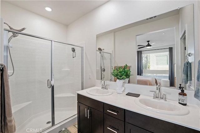 bathroom featuring vanity, ceiling fan, and a shower with shower door