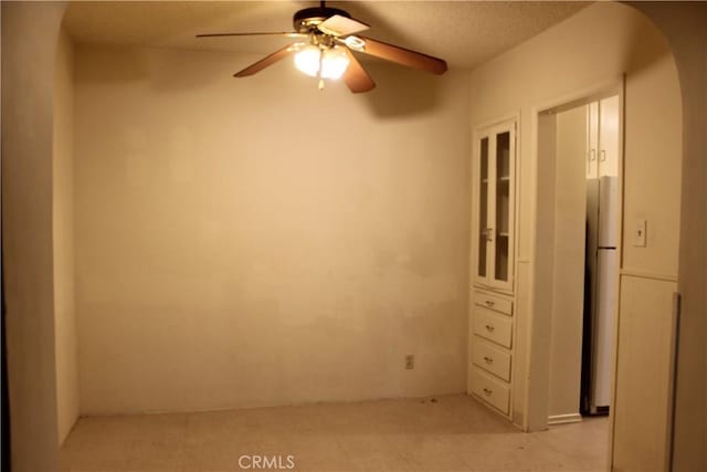 unfurnished room featuring a textured ceiling and ceiling fan