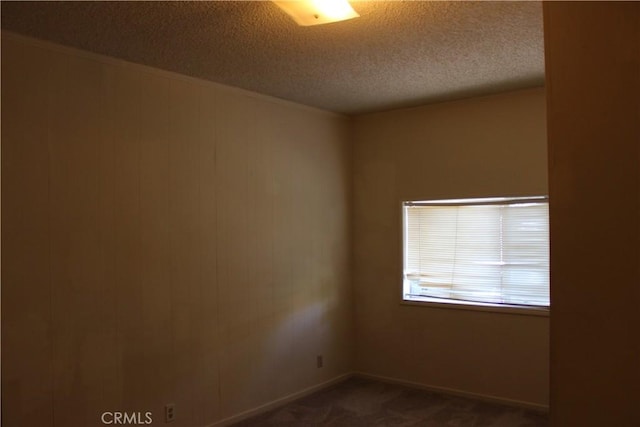 carpeted empty room with a textured ceiling