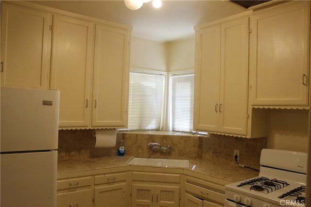 kitchen featuring white appliances, tile countertops, white cabinetry, and sink