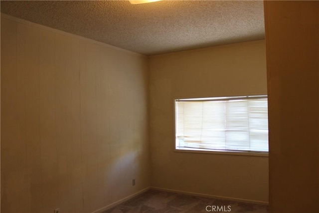 carpeted empty room with a textured ceiling