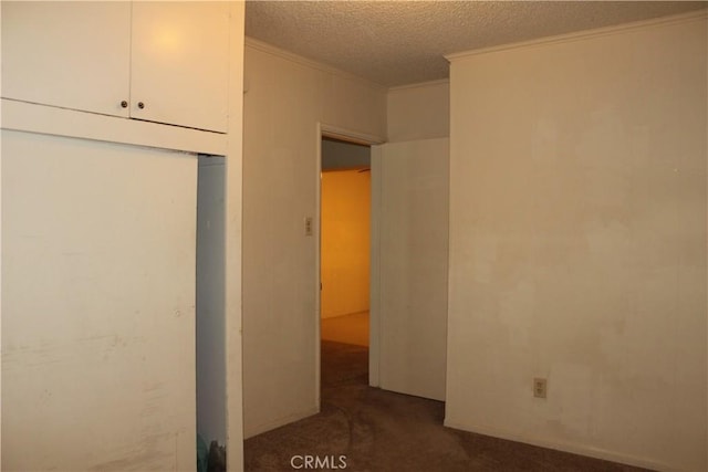 unfurnished bedroom with dark colored carpet, crown molding, and a textured ceiling