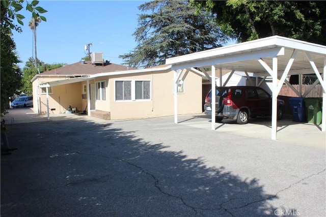 view of front facade with a carport and central AC