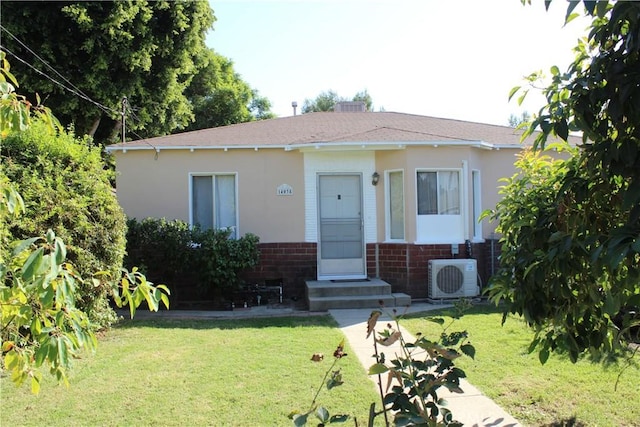 view of front of property featuring ac unit and a front yard