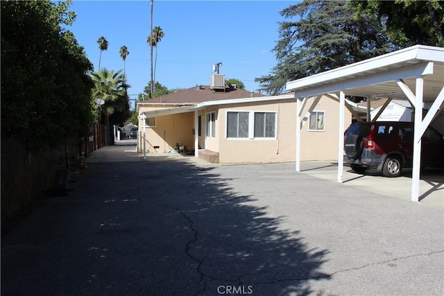 view of front of house featuring a carport and central air condition unit