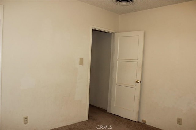 carpeted spare room featuring a textured ceiling