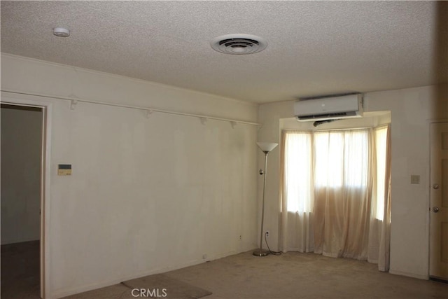 carpeted empty room with a textured ceiling and a wall unit AC