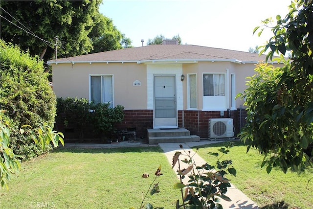 view of front of property featuring ac unit and a front yard